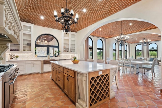 108 Country Vista Ln, Georgetown, TX 78626 - kitchen with brick ceiling, a chandelier, high end stove, lofted ceiling, and arched walkways