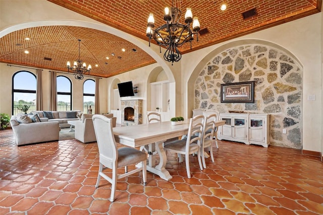 108 Country Vista Ln, Georgetown, TX 78626 - dining area with a chandelier, a lit fireplace, brick ceiling, arched walkways, and ornamental molding