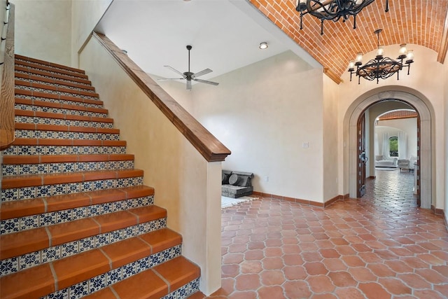 108 Country Vista Ln, Georgetown, TX 78626 - stairs with arched walkways, a chandelier, a ceiling fan, and vaulted ceiling