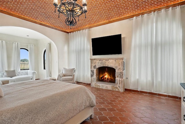 108 Country Vista Ln, Georgetown, TX 78626 - bedroom with a chandelier, a warm lit fireplace, and arched walkways