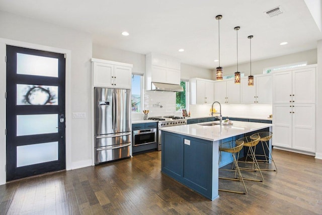 7000 Zachary Dr, Austin, TX 78724 - kitchen with stainless steel appliances, under cabinet range hood, white cabinetry, light countertops, and pendant lighting