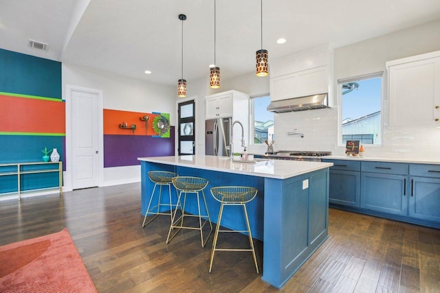 7000 Zachary Dr, Austin, TX 78724 - kitchen with stainless steel fridge, ventilation hood, recessed lighting, plenty of natural light, and dark wood finished floors