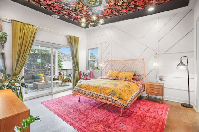 7000 Zachary Dr, Austin, TX 78724 - bedroom with access to outside, wood finished floors, and a decorative wall