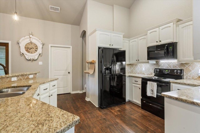 13 Mojave Ln, Belton, TX 76513 - kitchen featuring black appliances, arched walkways, dark wood finished floors, white cabinets, and tasteful backsplash
