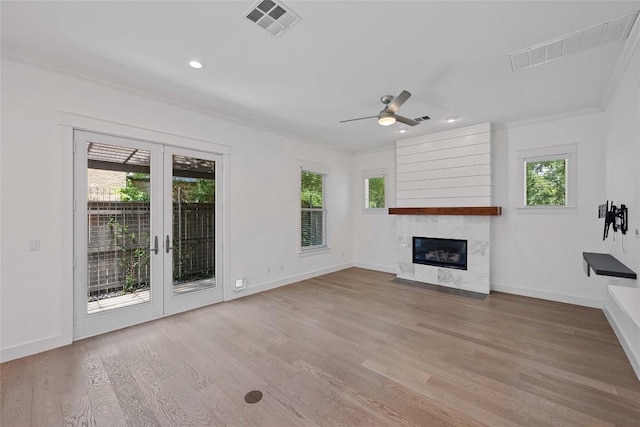 1403 W 12th St Unit B, Austin, TX 78703 - unfurnished living room with ornamental molding, plenty of natural light, a premium fireplace, wood finished floors, and recessed lighting