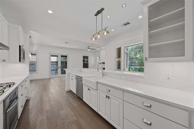 1403 W 12th St Unit B, Austin, TX 78703 - kitchen featuring appliances with stainless steel finishes, white cabinets, dark wood-style flooring, backsplash, and recessed lighting