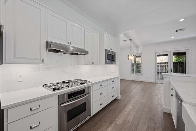 1403 W 12th St Unit B, Austin, TX 78703 - kitchen with stainless steel appliances, under cabinet range hood, light countertops, white cabinets, and recessed lighting