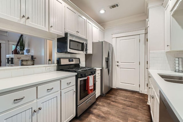 1117 Algarita Ave, Austin, TX 78704 - kitchen with stainless steel appliances, ornamental molding, white cabinets, tasteful backsplash, and recessed lighting