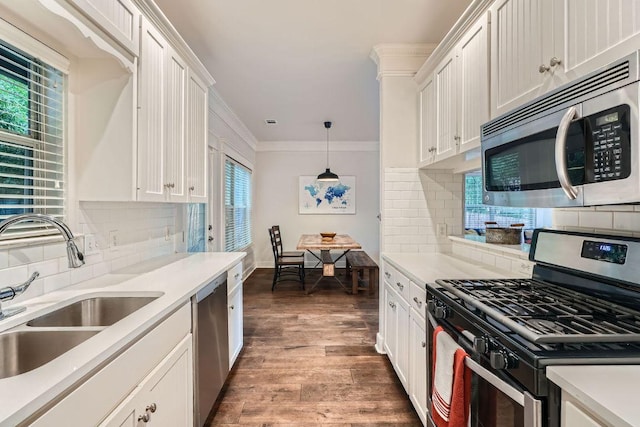 1117 Algarita Ave, Austin, TX 78704 - kitchen with appliances with stainless steel finishes, ornamental molding, white cabinetry, wood finished floors, and light countertops