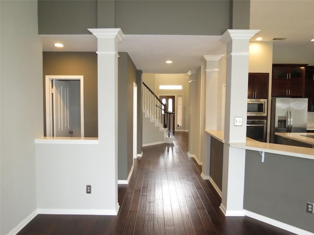 4008 Sable Oaks Dr, Round Rock, TX 78664 - kitchen featuring appliances with stainless steel finishes, decorative columns, light countertops, dark wood-style floors, and recessed lighting
