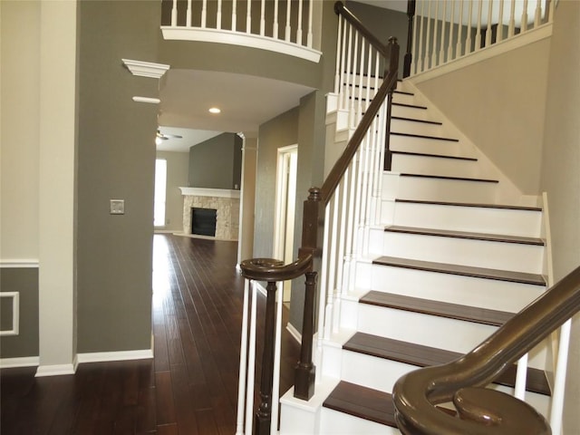 4008 Sable Oaks Dr, Round Rock, TX 78664 - stairway with a fireplace, hardwood / wood-style floors, a high ceiling, and a ceiling fan