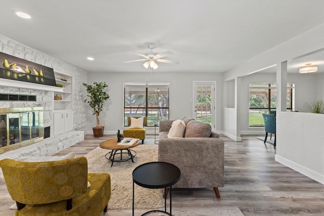 4003 Park Dr, Round Rock, TX 78681 - living room with built in features, wood finished floors, a ceiling fan, recessed lighting, and a fireplace