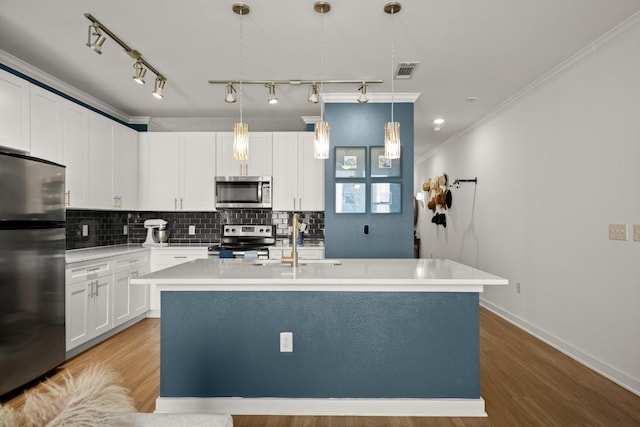 1900 Barton Springs Rd Unit 3038, Austin, TX 78704 - kitchen with stainless steel appliances, tasteful backsplash, ornamental molding, a center island with sink, and wood finished floors
