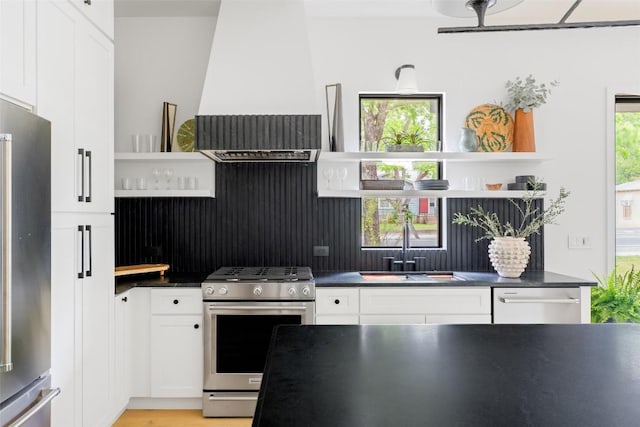 4911 Duval, Austin, TX 78751 - kitchen featuring open shelves, stainless steel appliances, white cabinets, and wall chimney exhaust hood