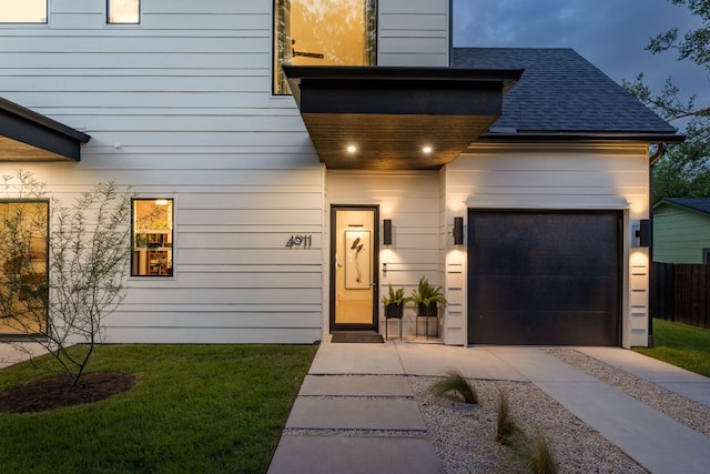 4911 Duval, Austin, TX 78751 - property entrance with an attached garage, concrete driveway, and roof with shingles
