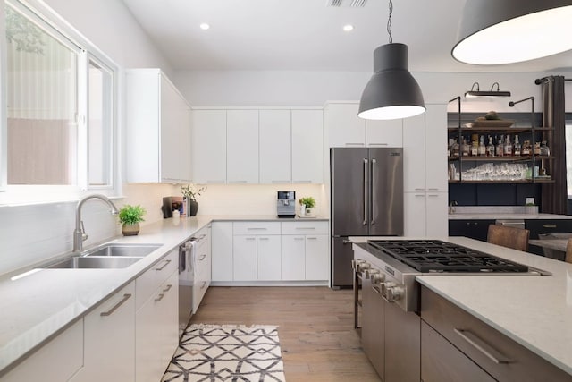 1303 Deloney St, Austin, TX 78721 - kitchen featuring stainless steel appliances, recessed lighting, decorative backsplash, light wood finished floors, and hanging light fixtures