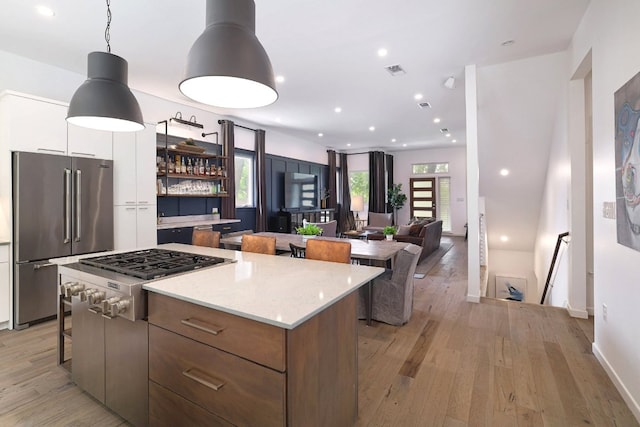 1303 Deloney St, Austin, TX 78721 - kitchen with stainless steel appliances, modern cabinets, a center island, light wood-style flooring, and a breakfast bar area