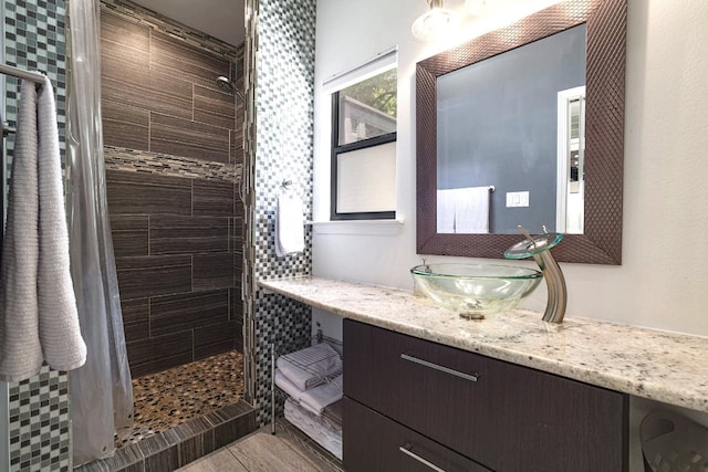 1305 Deloney St, Austin, TX 78721 - bathroom featuring a stall shower, vanity, and wood finished floors