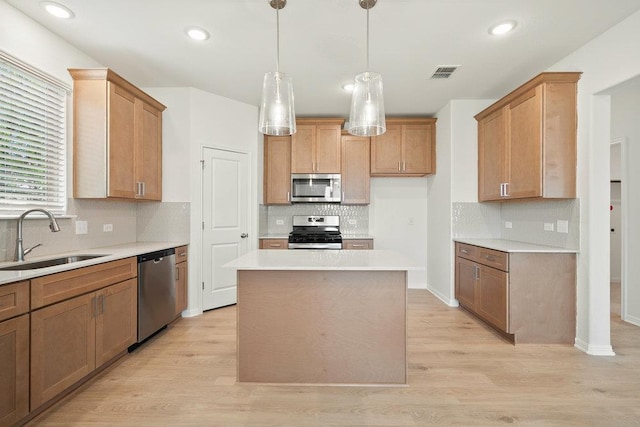 13228 Ditka Dr, Austin, TX 78652 - kitchen featuring appliances with stainless steel finishes, backsplash, light countertops, light wood-type flooring, and decorative light fixtures