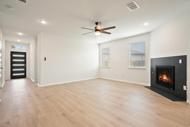 13228 Ditka Dr, Austin, TX 78652 - unfurnished living room featuring a tile fireplace, light wood-style floors, a ceiling fan, and recessed lighting