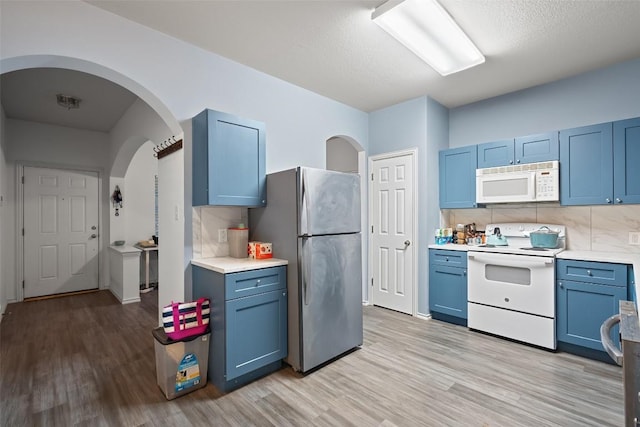 9206 Brents Elm Dr, Austin, TX 78744 - kitchen with white appliances, blue cabinets, and light wood-style floors