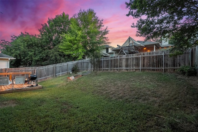 9206 Brents Elm Dr, Austin, TX 78744 - yard at dusk with a wooden deck and a fenced backyard