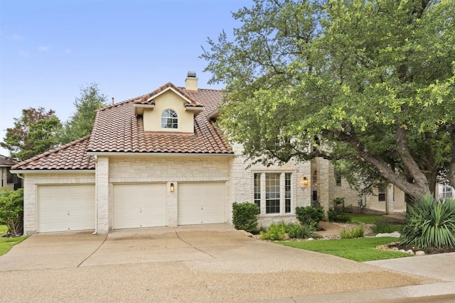 15908 Spillman Ranch Loop, Austin, TX 78738 - mediterranean / spanish-style house with a chimney, concrete driveway, stone siding, and a tiled roof