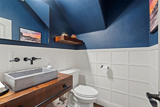 15908 Spillman Ranch Loop, Austin, TX 78738 - half bath with a textured wall, wainscoting, vanity, and a decorative wall
