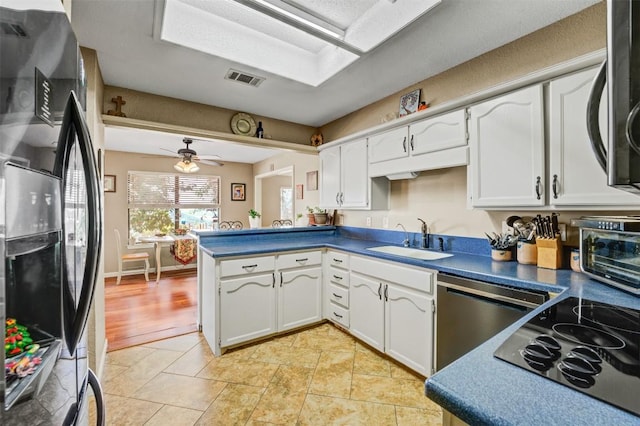 21013 Ridgeview Loop, Lago Vista, TX 78645 - kitchen with black appliances, white cabinetry, and dark countertops