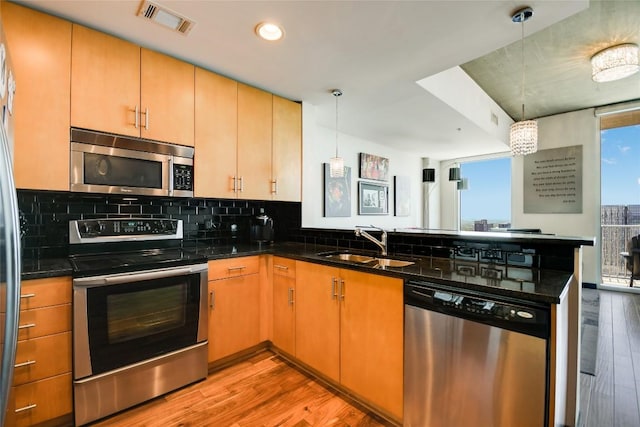 360 Nueces St Unit 3807, Austin, TX 78701 - kitchen with stainless steel appliances, a peninsula, light wood-type flooring, backsplash, and pendant lighting