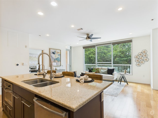 1600 Barton Springs Rd Unit 5107, Austin, TX 78704 - kitchen with stainless steel dishwasher, light wood-style floors, a ceiling fan, recessed lighting, and a kitchen island with sink