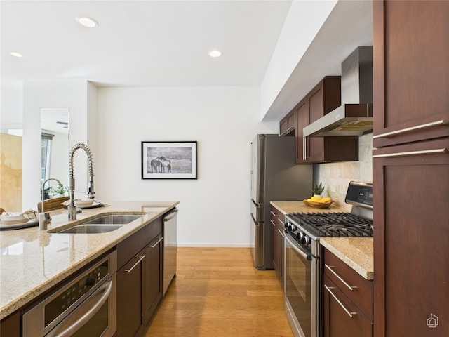 1600 Barton Springs Rd Unit 5107, Austin, TX 78704 - kitchen with wall chimney range hood, appliances with stainless steel finishes, light wood-style floors, light stone counters, and recessed lighting