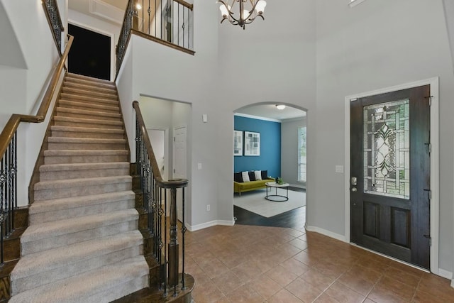 7617 Roaring Springs Dr, Austin, TX 78736 - tiled entryway with arched walkways, stairs, a towering ceiling, and a chandelier