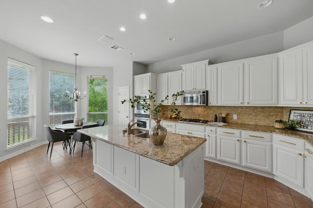 7617 Roaring Springs Dr, Austin, TX 78736 - kitchen with appliances with stainless steel finishes, tile patterned floors, tasteful backsplash, recessed lighting, and a chandelier