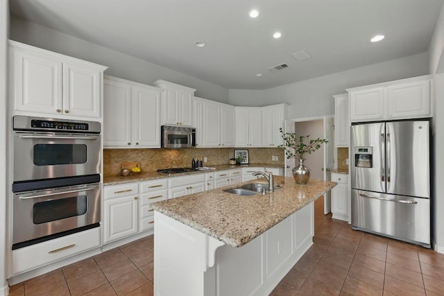 7617 Roaring Springs Dr, Austin, TX 78736 - kitchen with appliances with stainless steel finishes, tile patterned flooring, white cabinetry, and recessed lighting