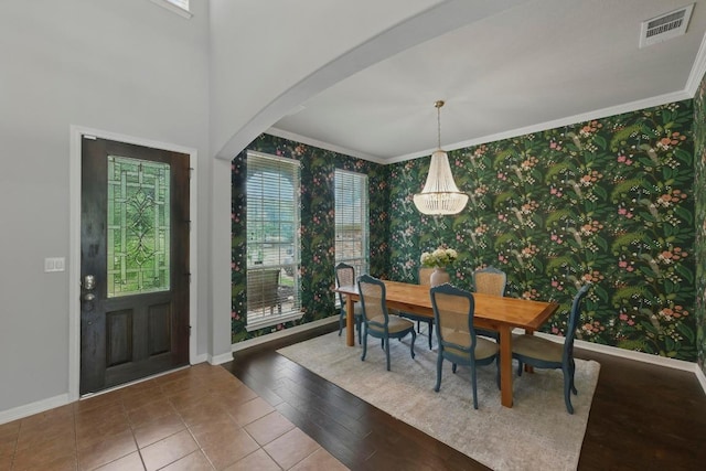 7617 Roaring Springs Dr, Austin, TX 78736 - dining room featuring wallpapered walls, healthy amount of natural light, arched walkways, ornamental molding, and wood finished floors