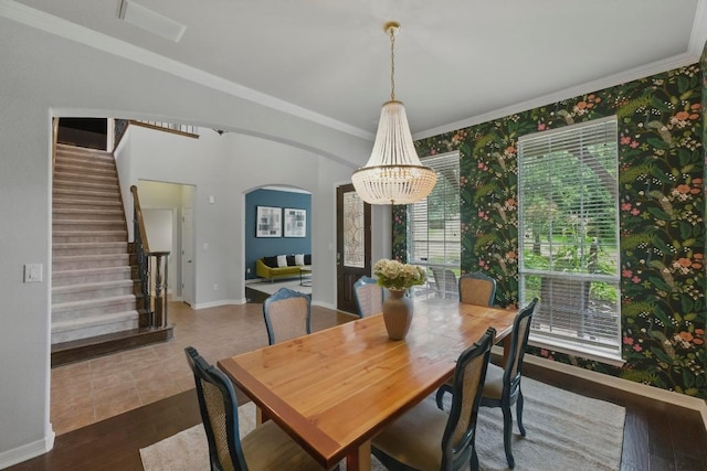 7617 Roaring Springs Dr, Austin, TX 78736 - dining space featuring a chandelier, arched walkways, crown molding, stairway, and wood finished floors