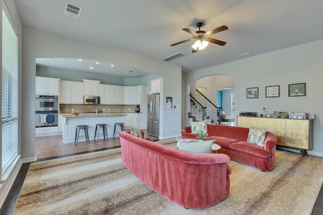 7617 Roaring Springs Dr, Austin, TX 78736 - living area with arched walkways, ceiling fan, stairs, and recessed lighting