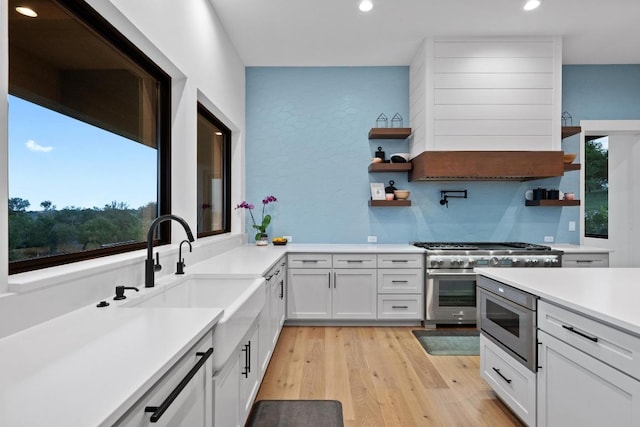 111 Rock N Robyn Trl, Horseshoe Bay, TX 78657 - kitchen with open shelves, double oven range, premium range hood, recessed lighting, and light wood-style floors
