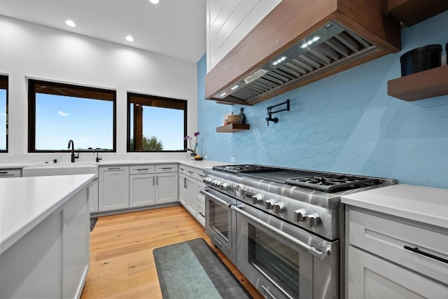 111 Rock N Robyn Trl, Horseshoe Bay, TX 78657 - kitchen with range with two ovens, premium range hood, light countertops, tasteful backsplash, and recessed lighting