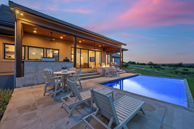 111 Rock N Robyn Trl, Horseshoe Bay, TX 78657 - outdoor pool with a ceiling fan, a patio, outdoor dining space, and exterior kitchen