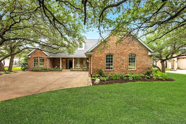 509 Explorer Dr, Lakeway, TX 78734 - view of front of property with brick siding, a front yard, roof with shingles, and driveway