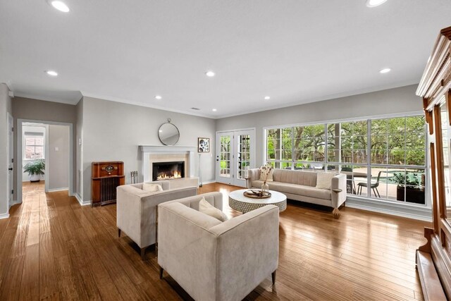 509 Explorer Dr, Lakeway, TX 78734 - living room featuring a lit fireplace, healthy amount of natural light, wood-type flooring, recessed lighting, and crown molding