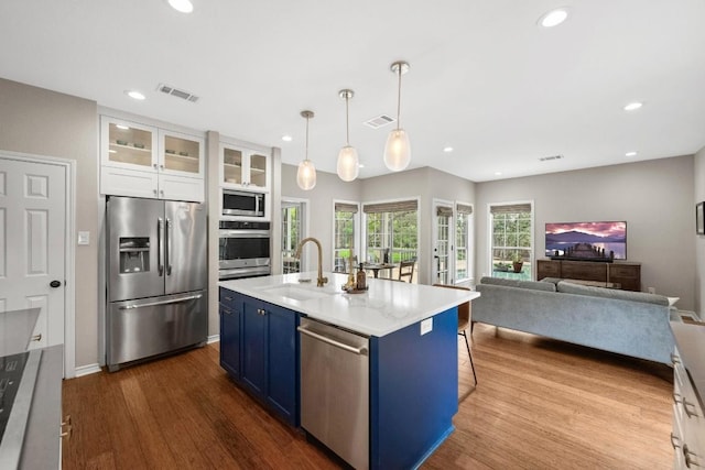 509 Explorer Dr, Lakeway, TX 78734 - kitchen with stainless steel appliances, blue cabinetry, dark wood finished floors, white cabinetry, and recessed lighting