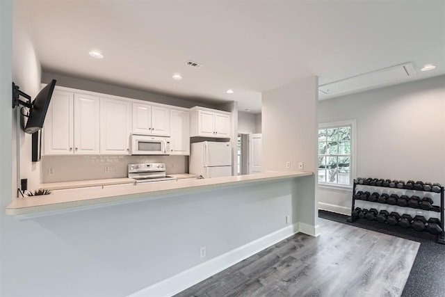 7503 Stonecliff Cir, Austin, TX 78731 - kitchen with white appliances, a peninsula, white cabinets, light countertops, and recessed lighting