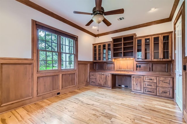 7503 Stonecliff Cir, Austin, TX 78731 - unfurnished office featuring built in study area, crown molding, wainscoting, light wood finished floors, and a ceiling fan