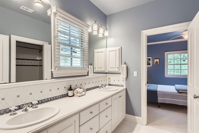 7503 Stonecliff Cir, Austin, TX 78731 - ensuite bathroom featuring double vanity, tile patterned flooring, and backsplash