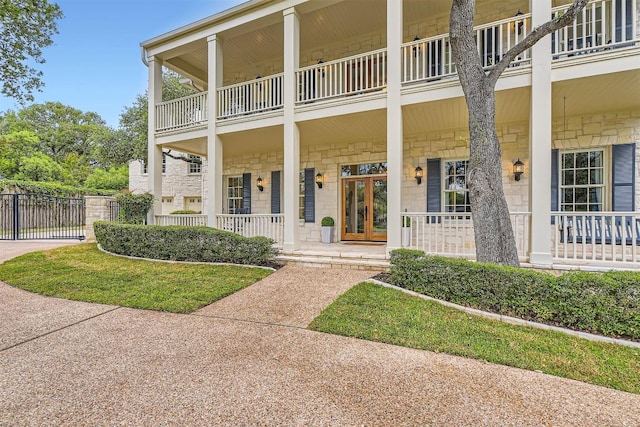 7503 Stonecliff Cir, Austin, TX 78731 - doorway to property featuring a balcony, covered porch, and stone siding