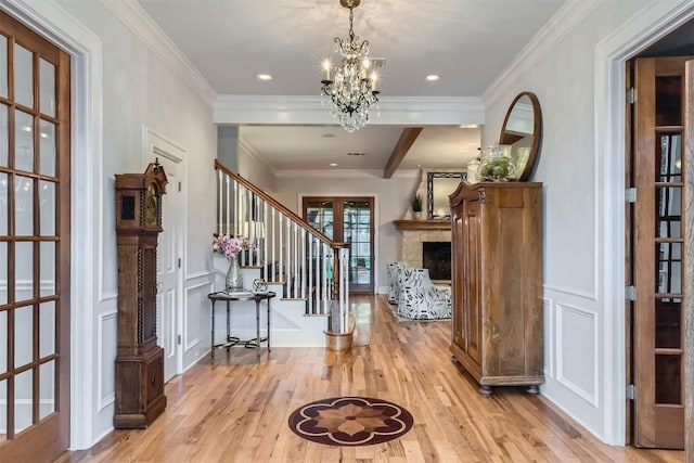 7503 Stonecliff Cir, Austin, TX 78731 - entryway featuring wood finished floors, stairway, a chandelier, crown molding, and a fireplace