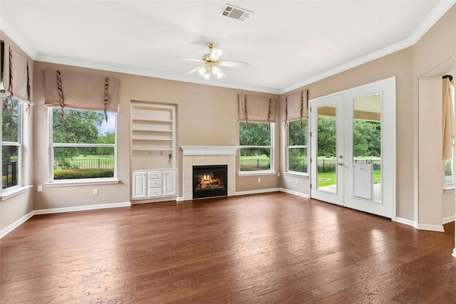 130 Enchanted Dr, Georgetown, TX 78633 - unfurnished living room with crown molding, a ceiling fan, wood-type flooring, a fireplace, and french doors